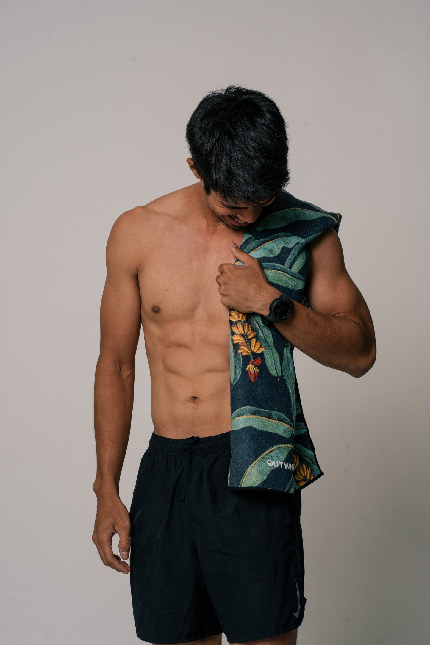 Male model wearing Outwhere PH Everywhere towel in Saging Green across his shoulders