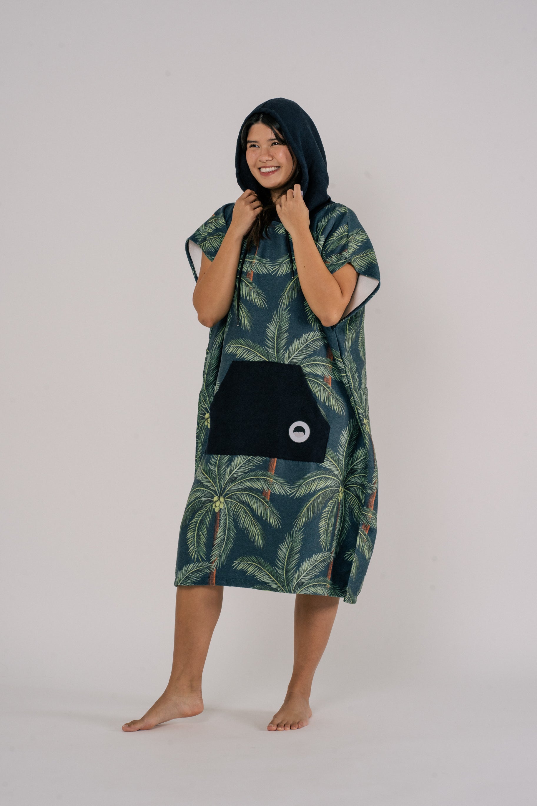 Female model wearing Outwhere Changing Poncho Towel in Buko design, Coconut tree print