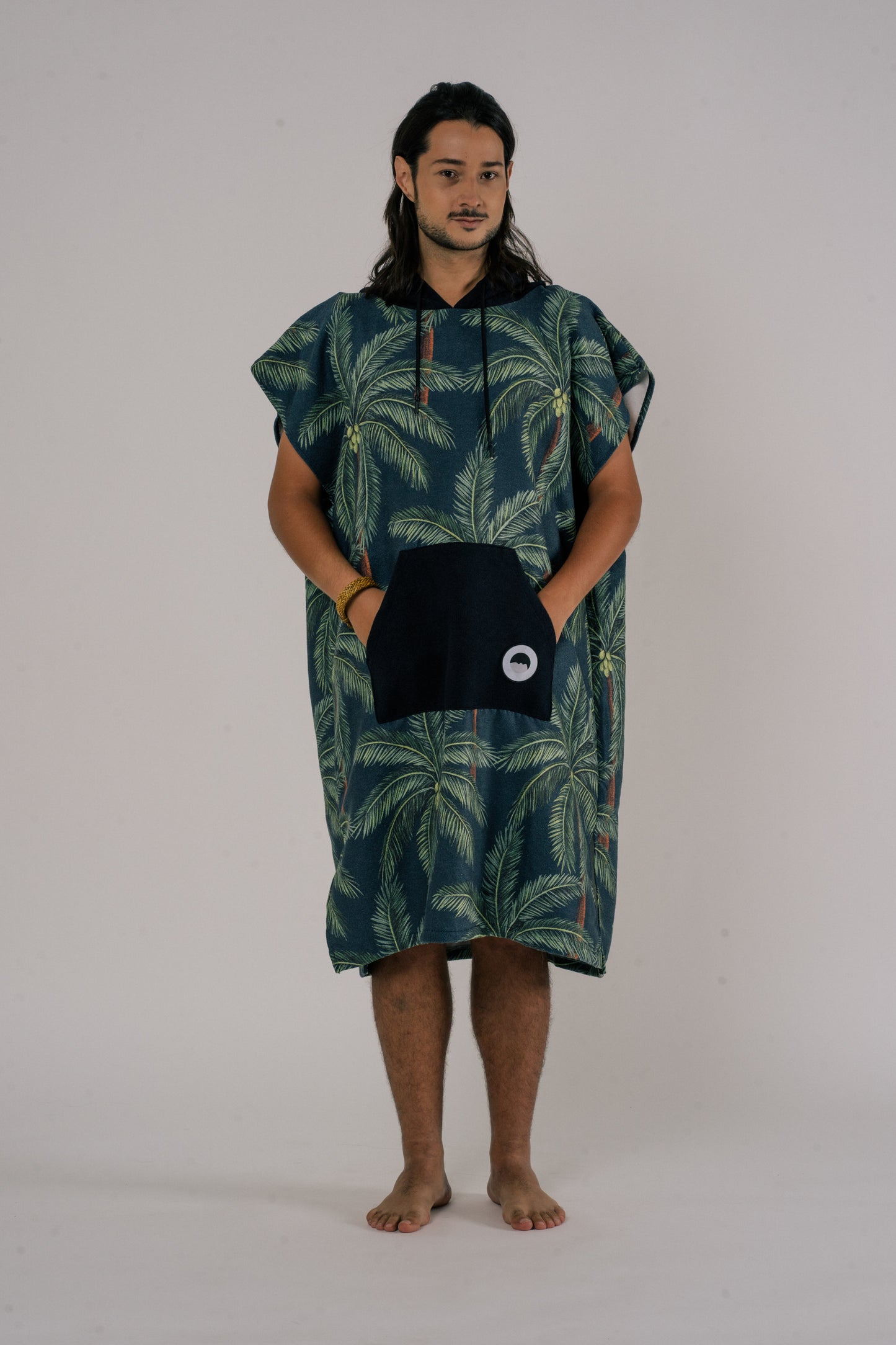 Male wearing Outwhere Changing Poncho Towel in Buko design, Coconut tree print with hands in pocket