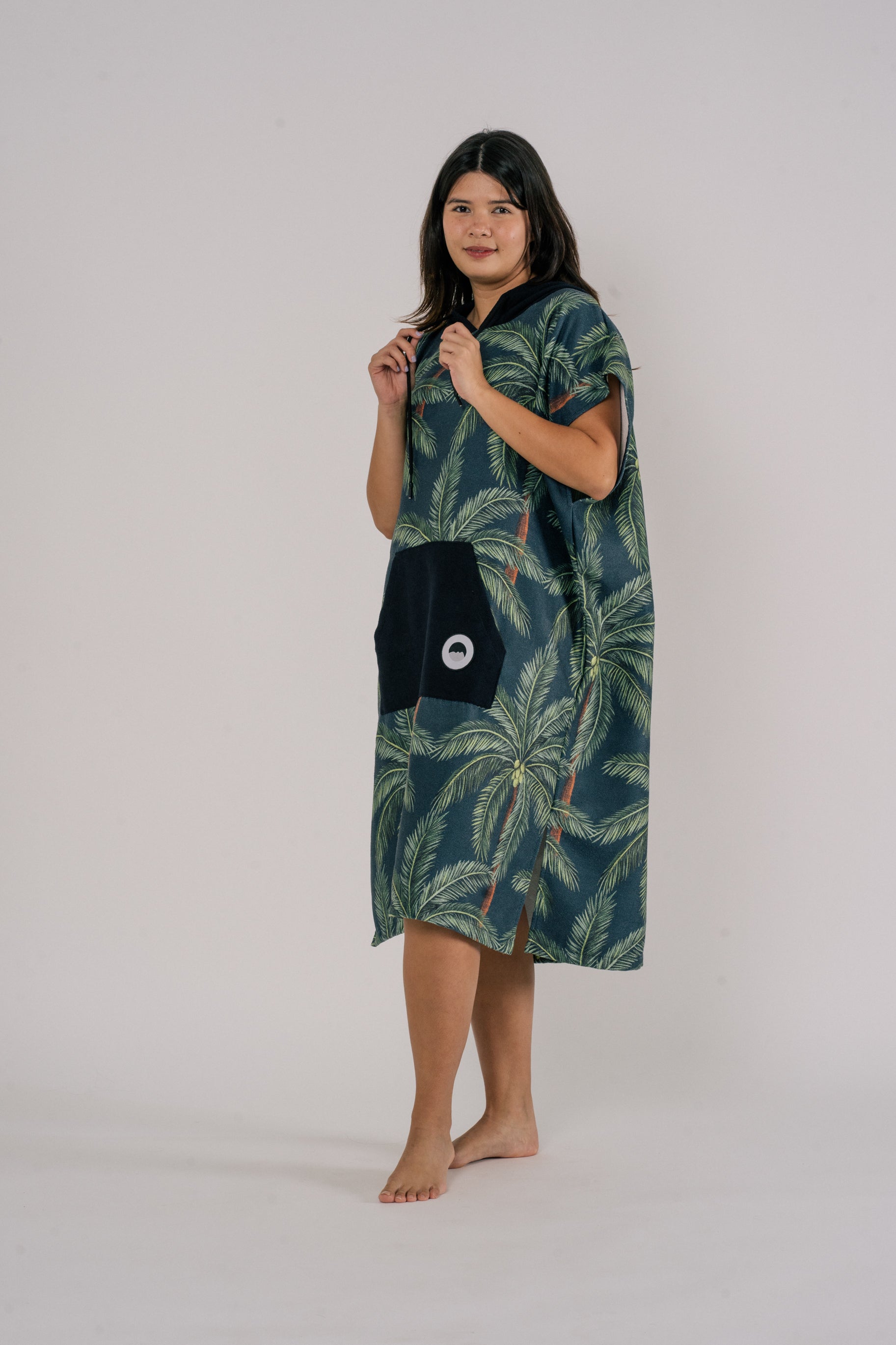 Female wearing Outwhere Changing Poncho Towel in Buko design holding drawstring, Coconut tree print