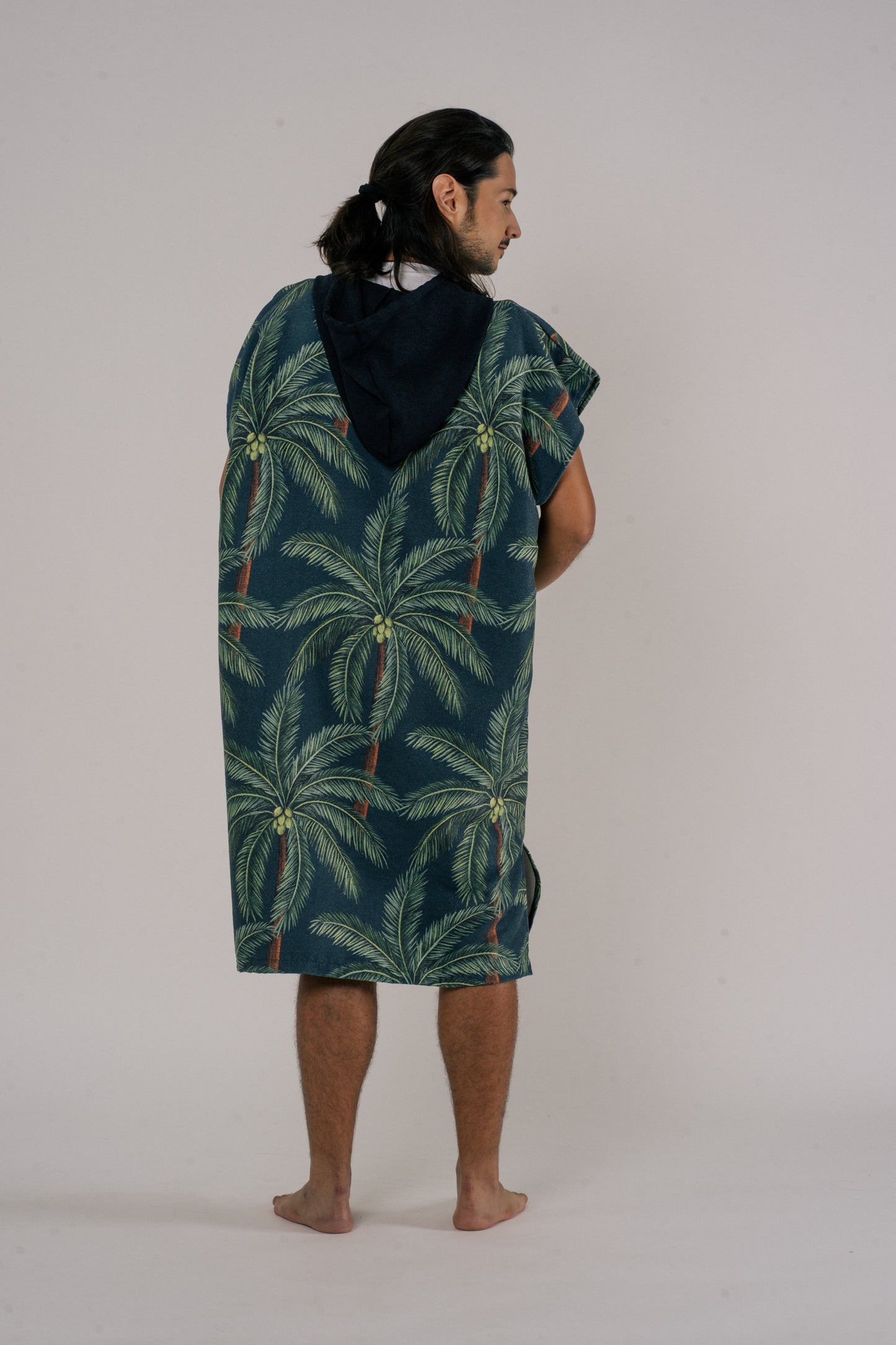 Male wearing Outwhere Changing Poncho Towel in Buko design showing back of print, Coconut tree print