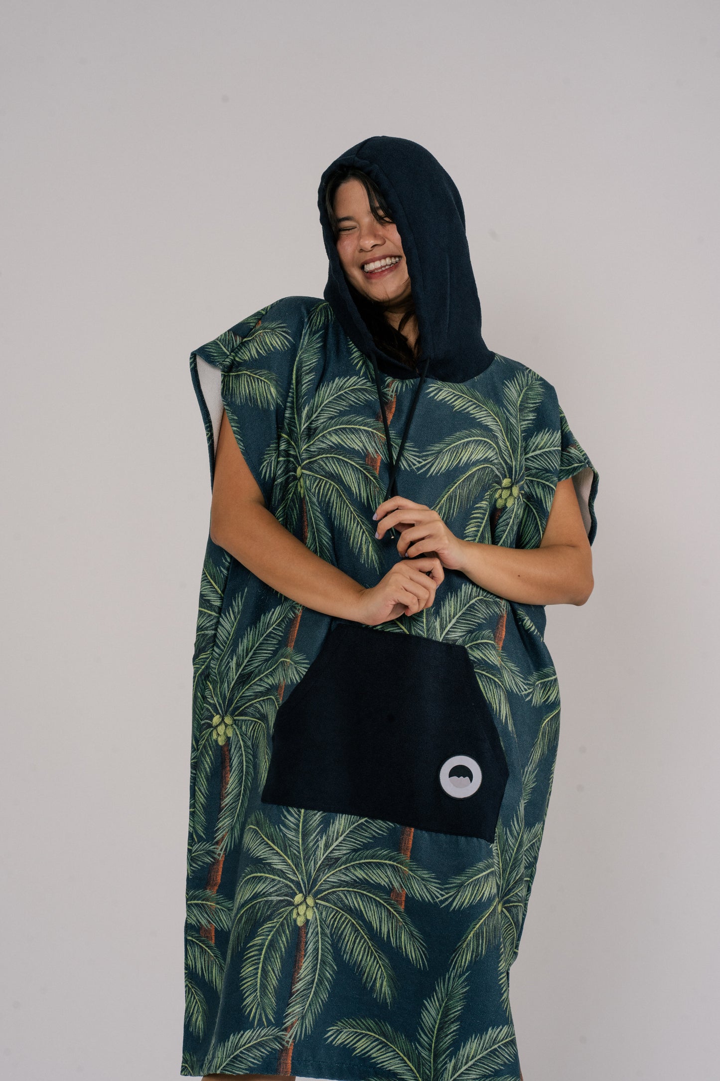 Female model wearing Outwhere Changing Poncho Towel in Buko design, Coconut tree print