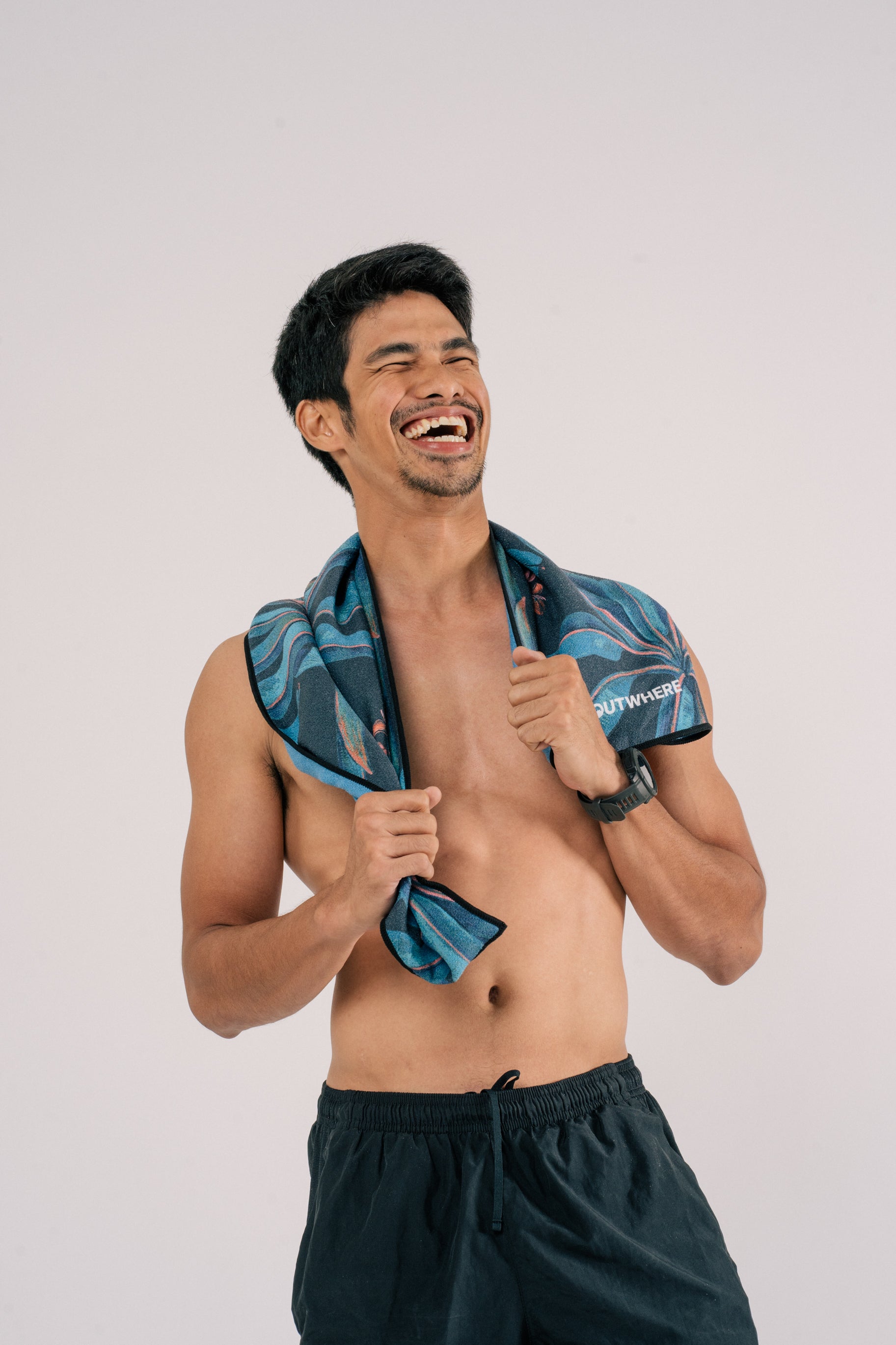 Male model wearing Outwhere PH Everywhere towel in Saging blue across his shoulders