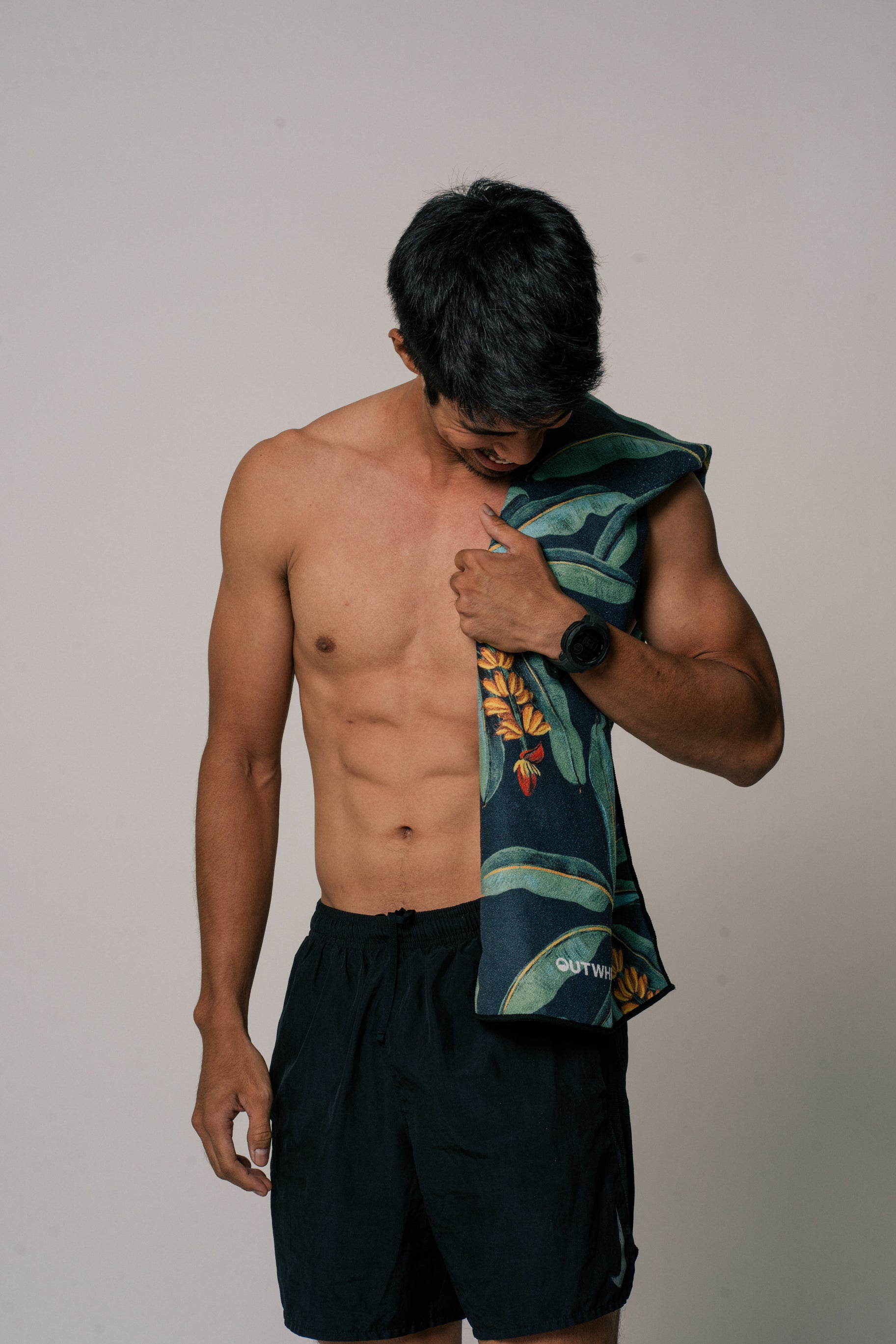 Male model wearing Outwhere PH Everywhere towel in Saging Green across his shoulders