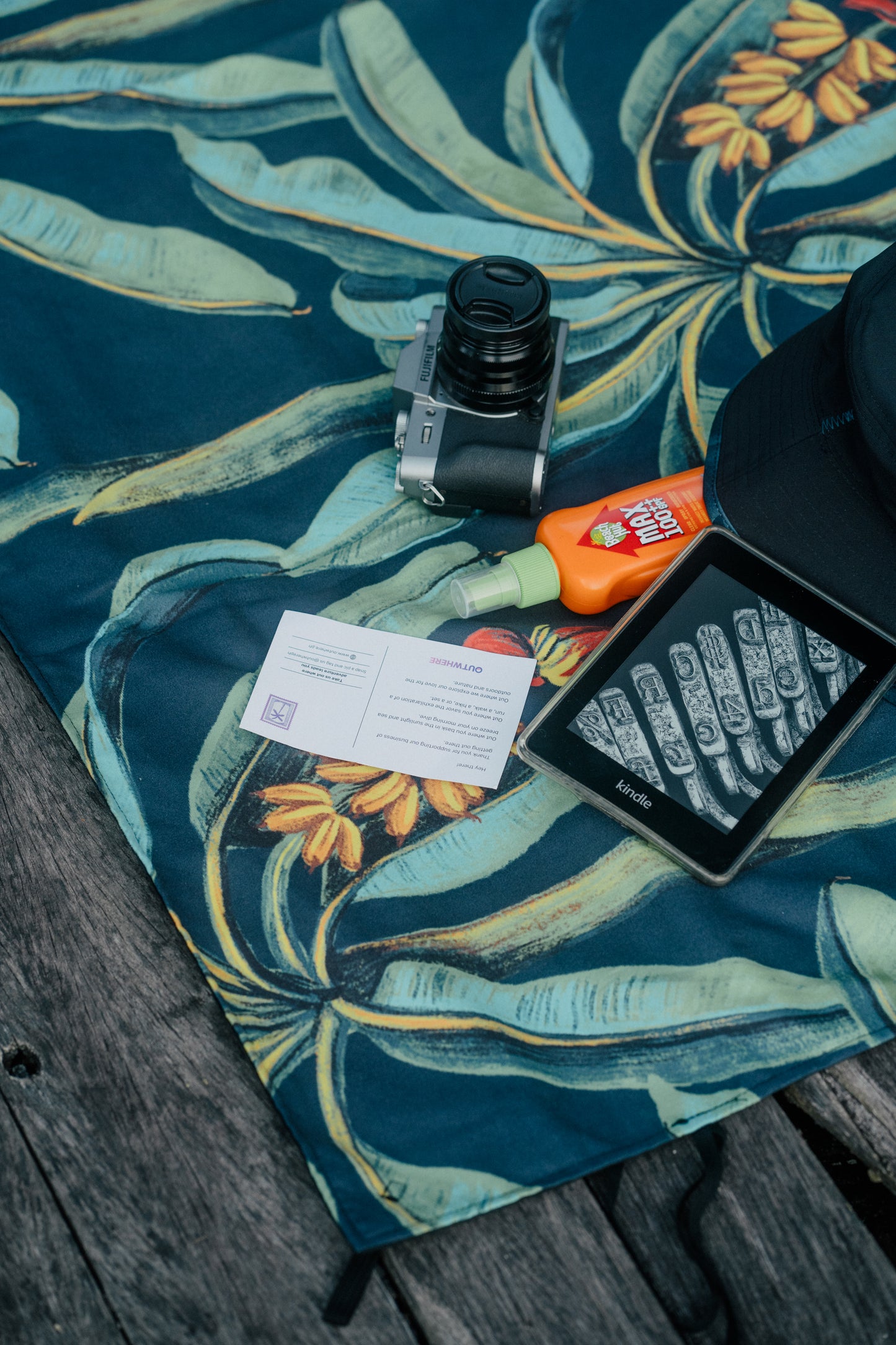 Close up shot of the Outwhere PH Latag mat in Saging with items on top - camera, sunblock, kindle, hat, postcard